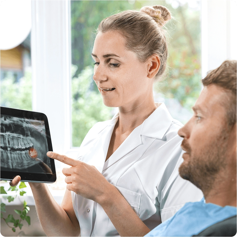 Dentist showing wisdom tooth to patient