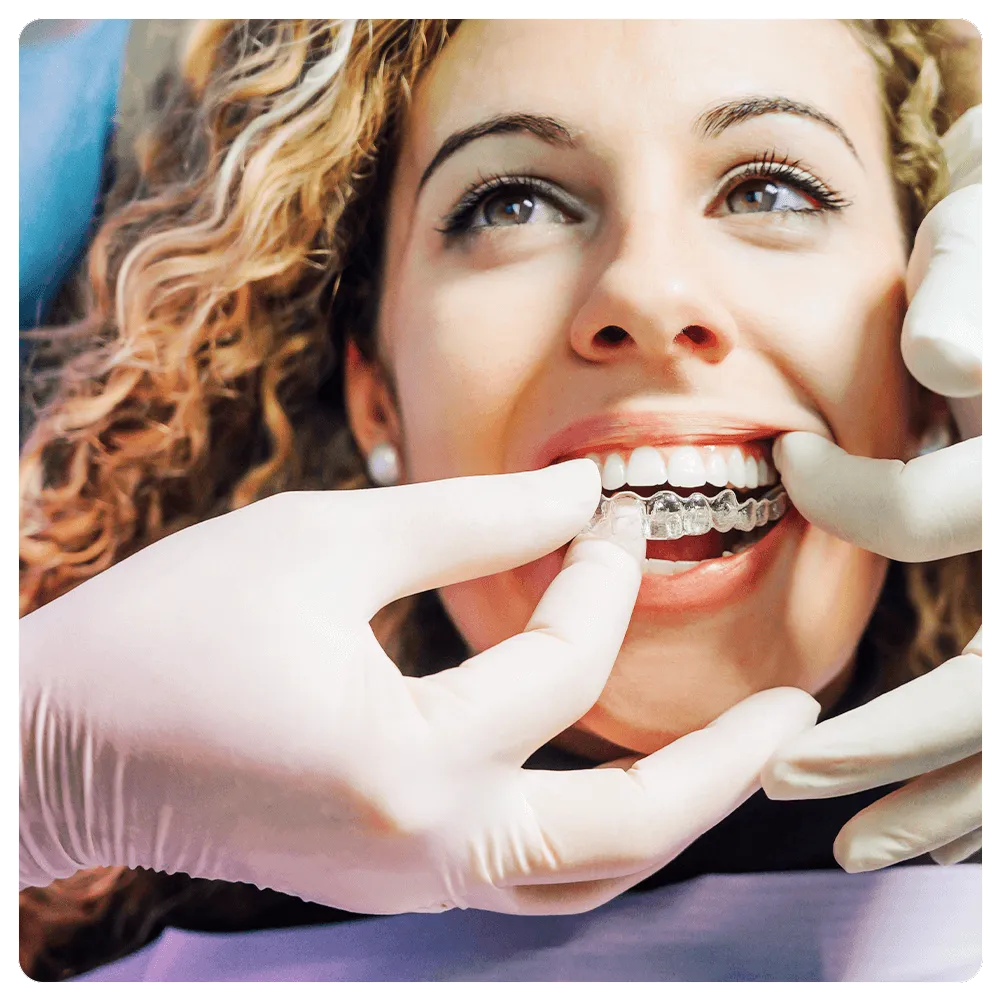 Dentist placing aligner on patient