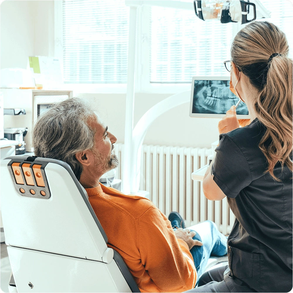 Dentist showing dental x-rays to patient