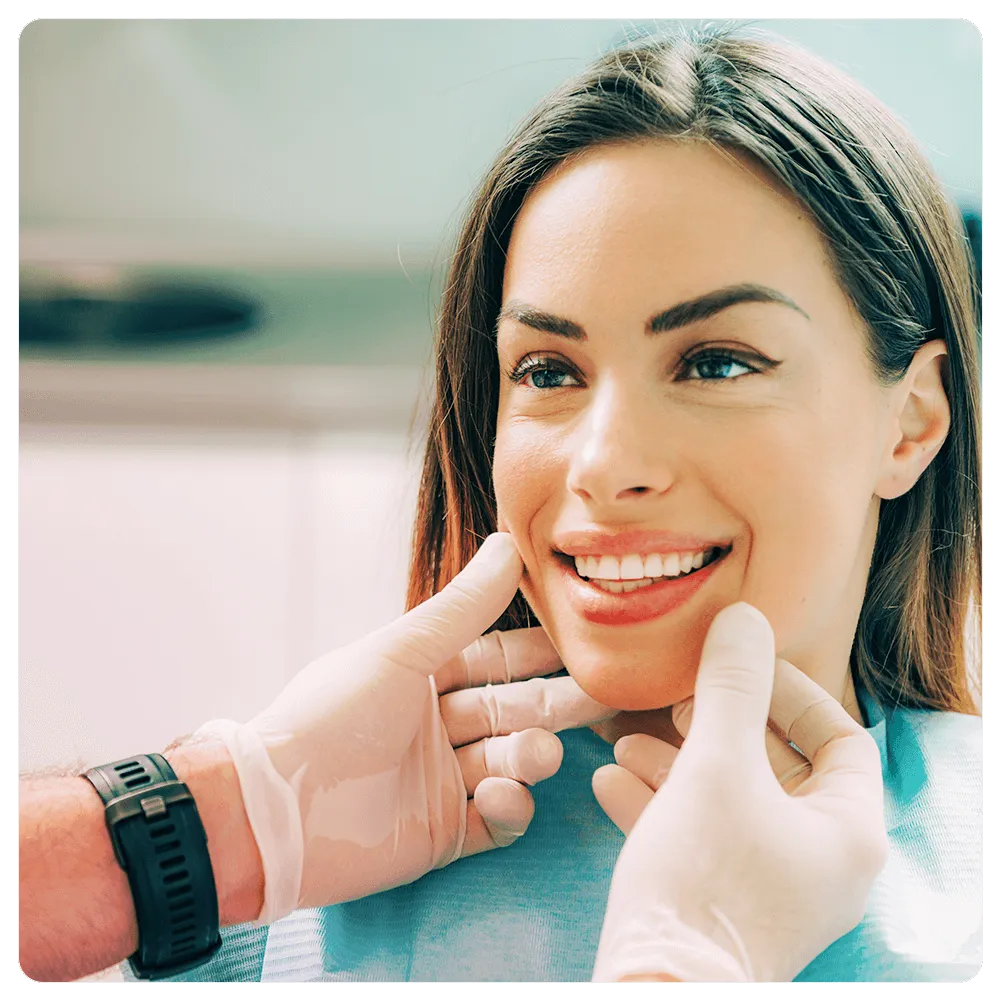 Patient smiling with dentist's hands