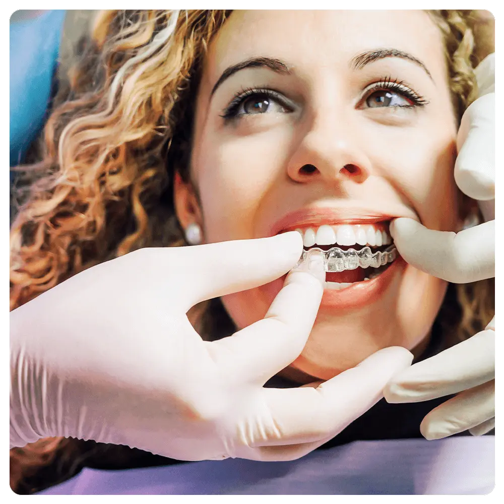 Dentist placing aligner on patient